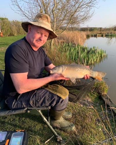 a man holding a fish in a basket at New Farm Cheshire Holidays in Winsford