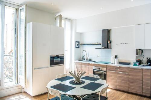 une cuisine avec une table et des chaises dans une pièce dans l'établissement Grand 2 chambres avec balcon Parc Longchamp, à Marseille