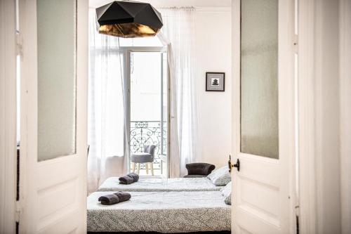 - une chambre avec deux lits en face d'une fenêtre dans l'établissement Grand 2 chambres avec balcon Parc Longchamp, à Marseille