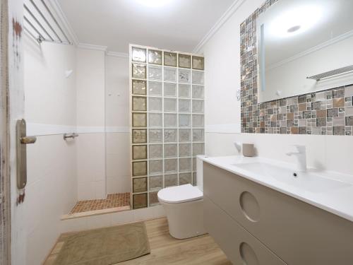 a bathroom with a toilet and a sink and a shower at Esmeralda Beach in Torrevieja