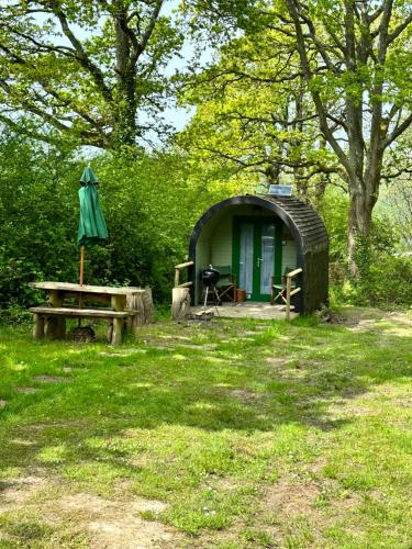 een kleine hut met een tafel en een paraplu bij New Acre Pod in Angmering