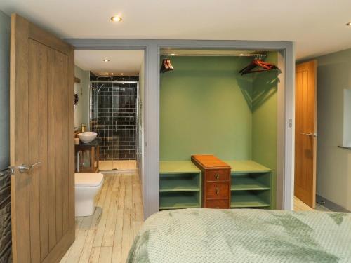 a bedroom with a bathroom with a toilet and a sink at Becket's Barn in Okehampton