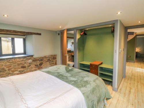 a bedroom with a bed and a stone wall at Becket's Barn in Okehampton