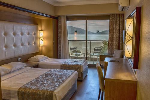 a hotel room with two beds and a balcony at Pasa Beach Hotel in Marmaris