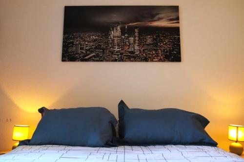 ein Schlafzimmer mit einem Bett mit zwei blauen Kissen in der Unterkunft Pretty T3 in the heart of Clermont-Ferrand in Clermont-Ferrand