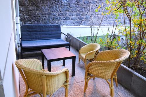 eine Gruppe Stühle und eine Bank auf dem Balkon in der Unterkunft Pretty T3 in the heart of Clermont-Ferrand in Clermont-Ferrand