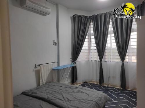 a bedroom with a bed and a window with curtains at Santai D' Mantin Homestay in Lengging