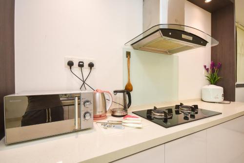 a kitchen with a microwave and a stove at Midvalley Southkey Mosaic Suite by Nest Home in Johor Bahru