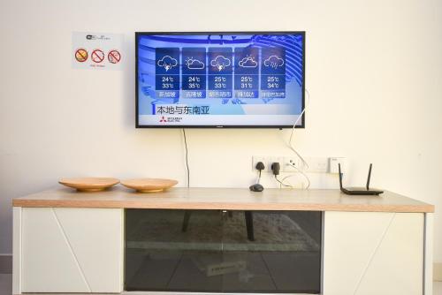 a television hanging on a wall with a desk at Midvalley Southkey Mosaic Suite by Nest Home in Johor Bahru