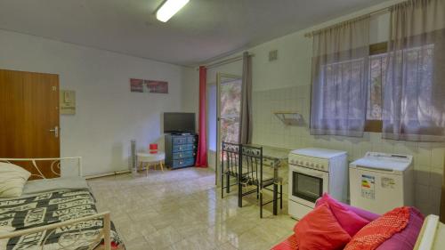 Studio plage في Santa-Maria-di-Lota: غرفة بسرير ومطبخ مع موقد
