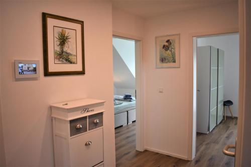 ein Schlafzimmer mit rosa Wänden, einer Kommode und einem Badezimmer in der Unterkunft Heiligenbergblick in Heidelberg