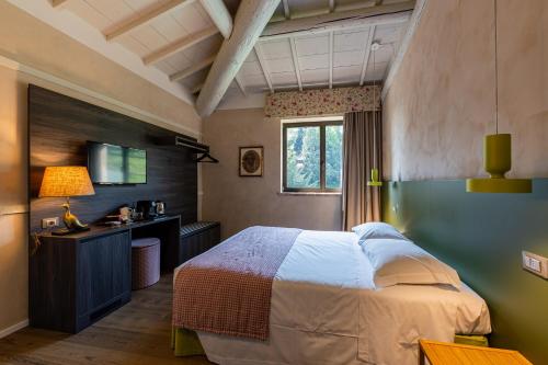 una camera con letto, scrivania e finestra di Relais Le Coste a Lavagno