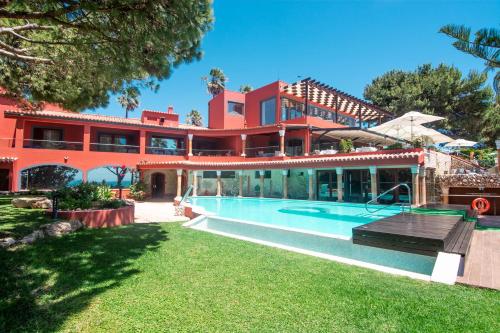 a large red building with a swimming pool at Boutique Hotel Vivenda Miranda in Lagos
