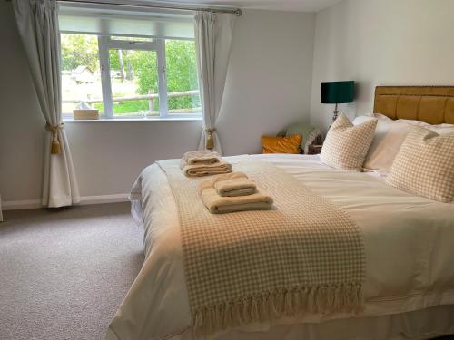 a bedroom with a bed with two towels on it at Brabands Cottage Rye in Iden