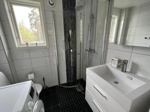 a white bathroom with a sink and a shower at Drömboende Tofta Södra in Gnisvärd