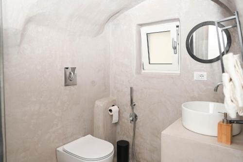 a bathroom with a sink and a toilet and a mirror at CASA FLAMI' 4 in Ostuni