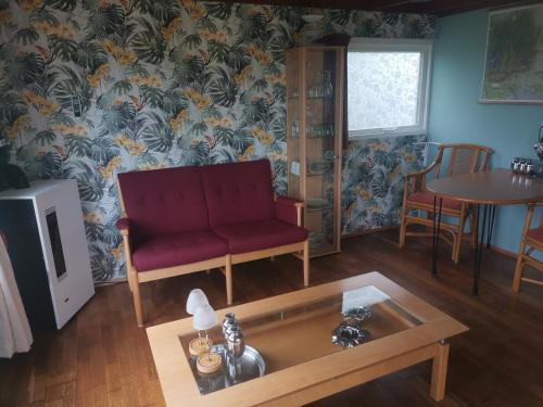 ein Wohnzimmer mit einem roten Sofa und einem Tisch in der Unterkunft Zilver'n Plekkie in Zeyen