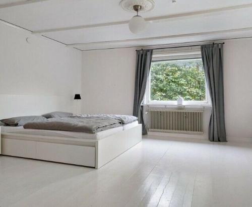 una camera bianca con un letto e una finestra di Ferienhaus Alfred a Ryd