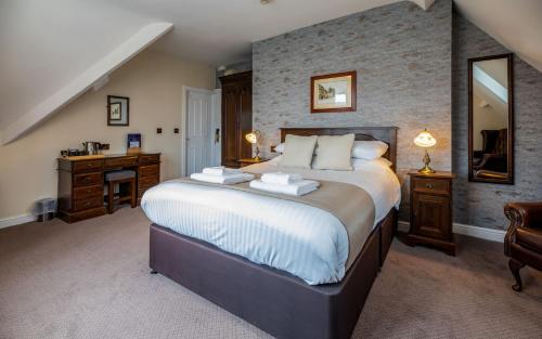 a bedroom with a large bed and a desk at White Lion Royal Hotel in Bala