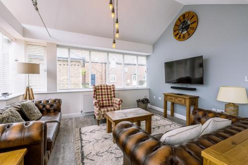 a living room with leather furniture and a flat screen tv at The Bay Filey in Filey