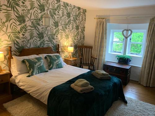 een slaapkamer met een bed met twee handdoeken erop bij Crosse Chance Cottage - Idyllic, beautiful, traditional cottage to love - Wood burner in Taddington