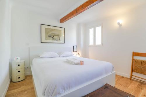 a white bedroom with a large white bed and a window at Le Chave - Appart 1 ch terrasse et climatisation in Marseille