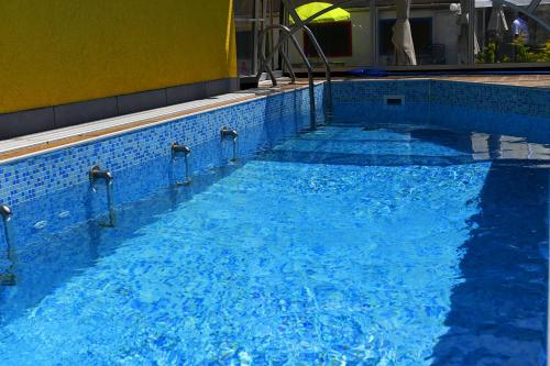 a large blue swimming pool with blue water at Tokajer Wellness Panzió in Keszthely