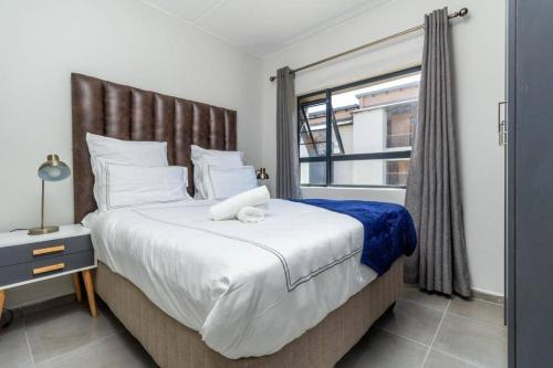 a bedroom with a large bed and a window at Smart apartment 322 in Midrand