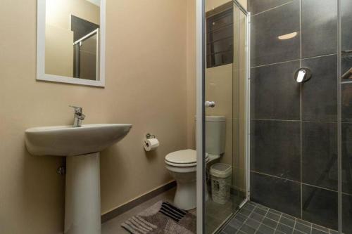 a bathroom with a toilet and a sink and a shower at Smart apartment 322 in Midrand