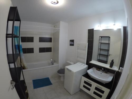 a bathroom with a sink and a toilet and a tub at SETième Art , centre Sète, 5 minutes de la gare in Sète