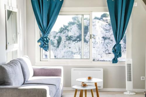 un salon avec un canapé et une fenêtre dans l'établissement Pieds dans l'eau - Terrasse vue mer 2 chambres, à Le Rove