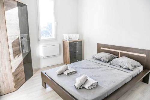 une chambre avec un lit avec deux serviettes dessus dans l'établissement Pieds dans l'eau - Terrasse vue mer 2 chambres, à Le Rove