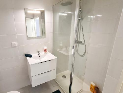 biała łazienka z prysznicem i umywalką w obiekcie Superbe appartement w mieście Dreux