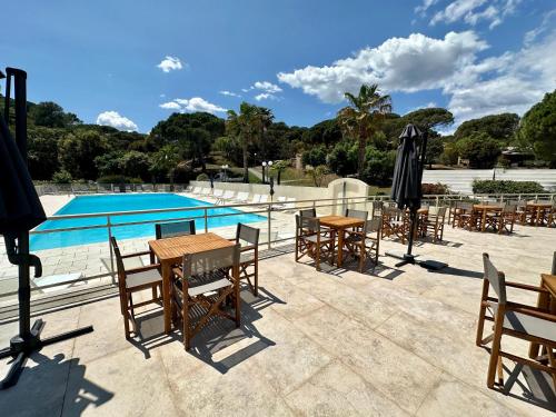a patio with tables and chairs next to a pool at LBV Les Bastidons de Villepey in Saint-Aygulf