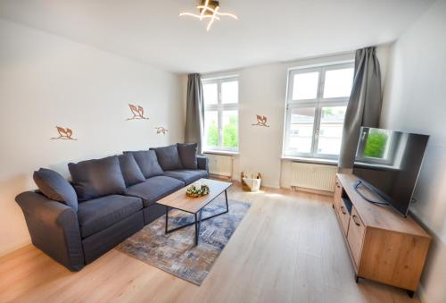 a living room with a couch and a flat screen tv at Apartmenthaus Fritz Reuter in Schwerin