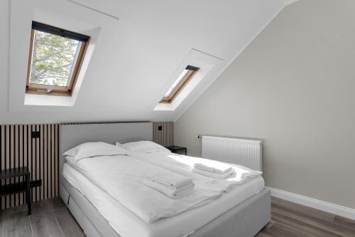 1 dormitorio con 1 cama blanca y 2 toallas en Central and Cozy Apartment, en Reikiavik