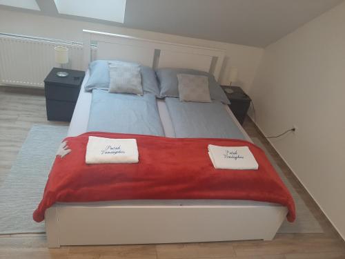 a bedroom with a bed with a red blanket on it at Patak Vendégház in Zalaegerszeg
