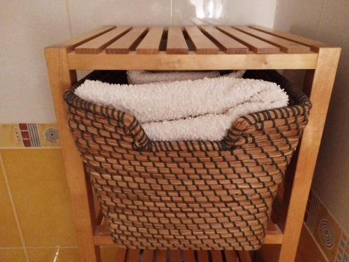 uma cesta com toalhas numa prateleira na casa de banho em Idafe em Valdemaqueda
