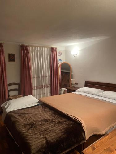 a bedroom with a large bed and a chair at Appartamento dolomiti in Auronzo di Cadore