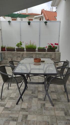 a glass table and chairs on a patio at Nikolas House - ΤΟ ΣΠΙΤΙ ΤΟΥ ΝΙΚΟΛΑ in Archea Pissa