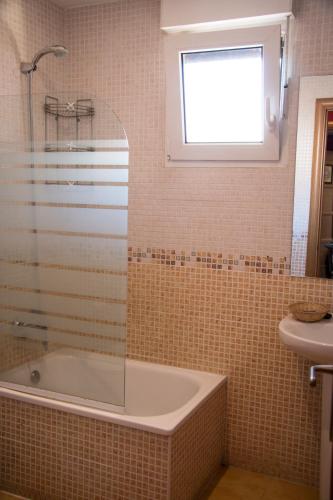 a bathroom with a tub and a sink and a window at Apartahotel Rural CollaRubio Luxury in Collado Mediano