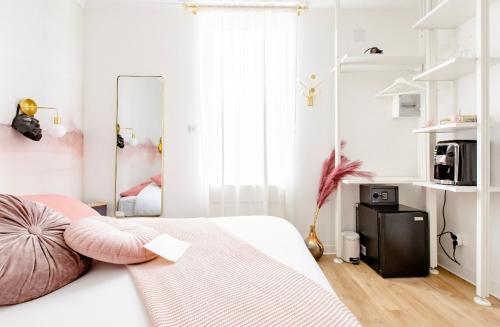 a white bedroom with a bed with pink pillows at Love Room LOsmose chambre Alchimie Bed and Breakfast Wimereux in Wimereux