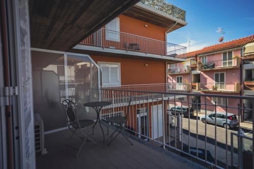 a balcony with a table and chairs on a building at Oasi Perla Del Mare Rooms in Aci Castello