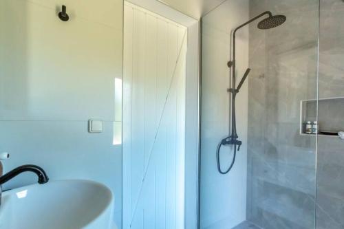 een badkamer met een douche, een wastafel en een glazen douchedeur bij Meraki Mou My pride and care in Spartia