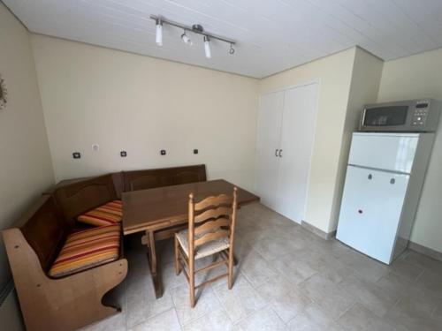 a small kitchen with a table and a refrigerator at Bas de villa en face du lac de Savines in Savines