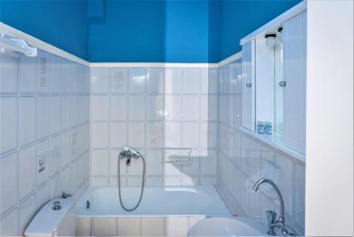 a bathroom with a tub and a shower and a sink at Zois Apartments in Nikiana