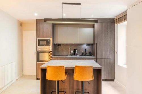 リヨンにあるCocoon du vieux Lyon - Luxury apartment - Balneoの島付きのキッチン(オレンジバースツール2つ付)