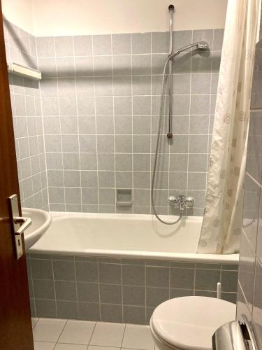 a bathroom with a tub and a toilet and a shower at Dünenschlösschen 22 in Wangerooge