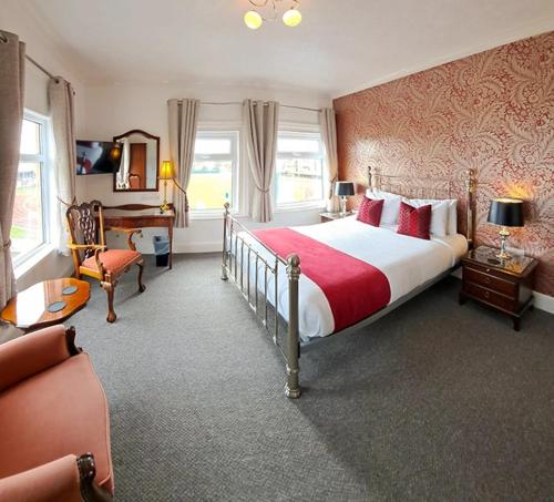 a bedroom with a large bed and a desk at Annabelle Rooms in Great Yarmouth