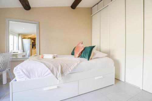 une chambre avec un lit blanc avec un miroir dans l'établissement Studio avec terrasse - Vieux Port & Cours Julien, à Marseille